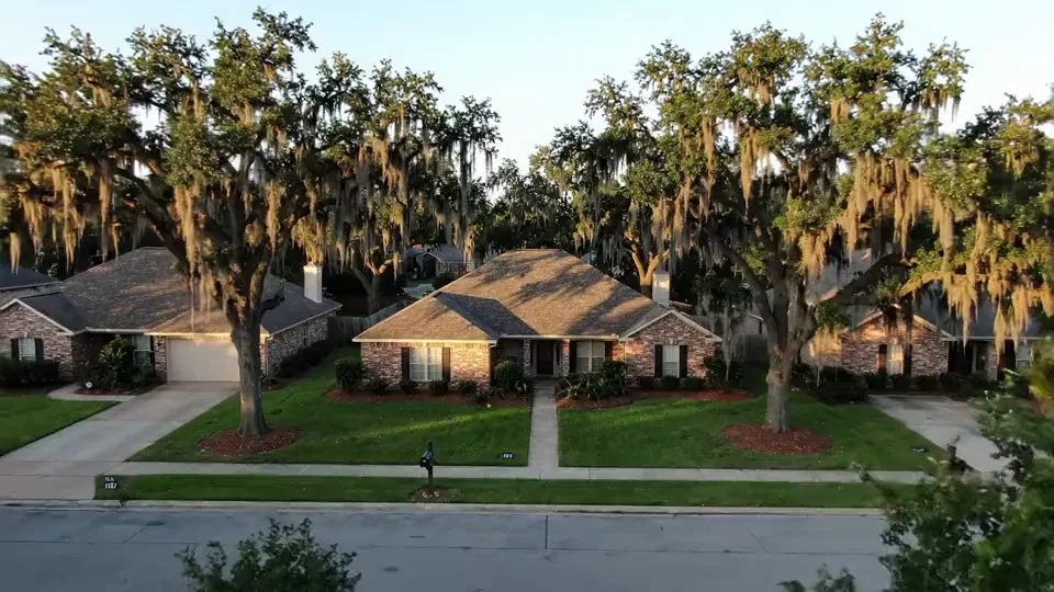 Aerial over a quiet Southern Louisiana street lined with oaks